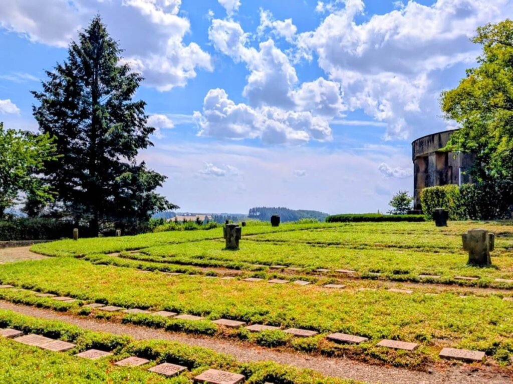 Ringförmig angelegte Grabfelder auf dem Ehrenfriedhof in Daleiden mit weitem Blick über die Südeifel
