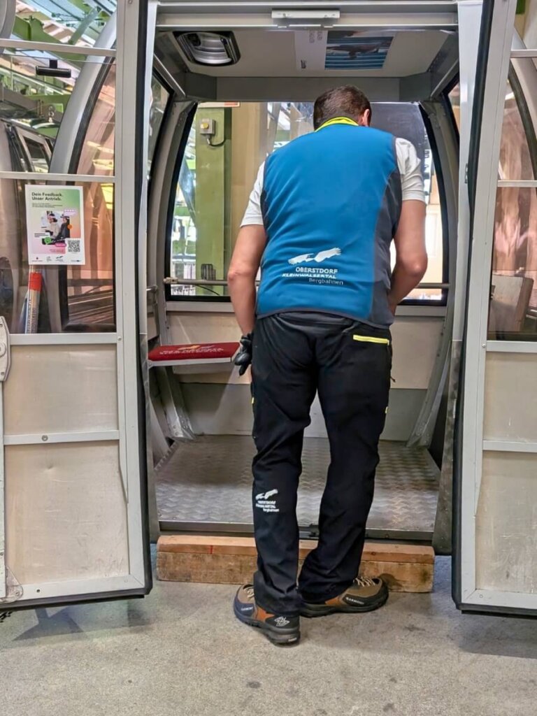 Mitarbeiter der Talstation bereitet die Gondel vor