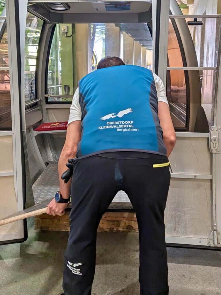 Mitarbeiter der Talstation legt die Rollstuhlrampe aus