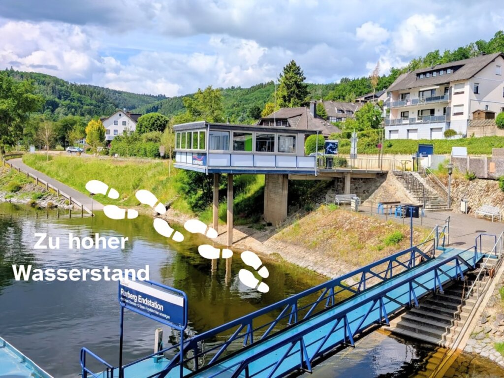 Anlegestelle Rurberg mit überflutetem Zugangsweg. Weiße Fußspuren markieren den normalerweise nutzbaren Weg für Rollstuhlfahrer.